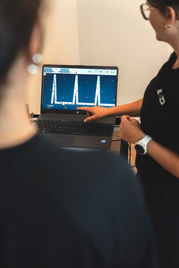 Physiothérapeute utilisant une sonde périnéale pour l’évaluation et le traitement en biofeedback lors d’une rééducation du plancher pelvien.